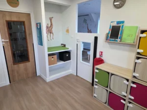 Entrée de la micro crèche avec des stickers girafes et des casiers colorés pour y déposer ses chaussures