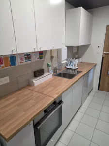 Cuisine de la micro crèche avec un plan de travail en bois et des éléments de cuisine blancs