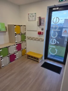 Porte d'entrée et casiers pour chaussures de la micro crèche avec des accroches pour les manteaux